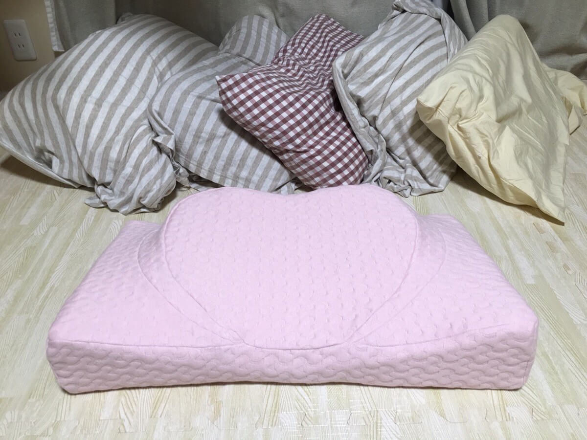 横向き寝用の枕の後ろに、合わなくて買い替えてきた枕が並んでいる写真