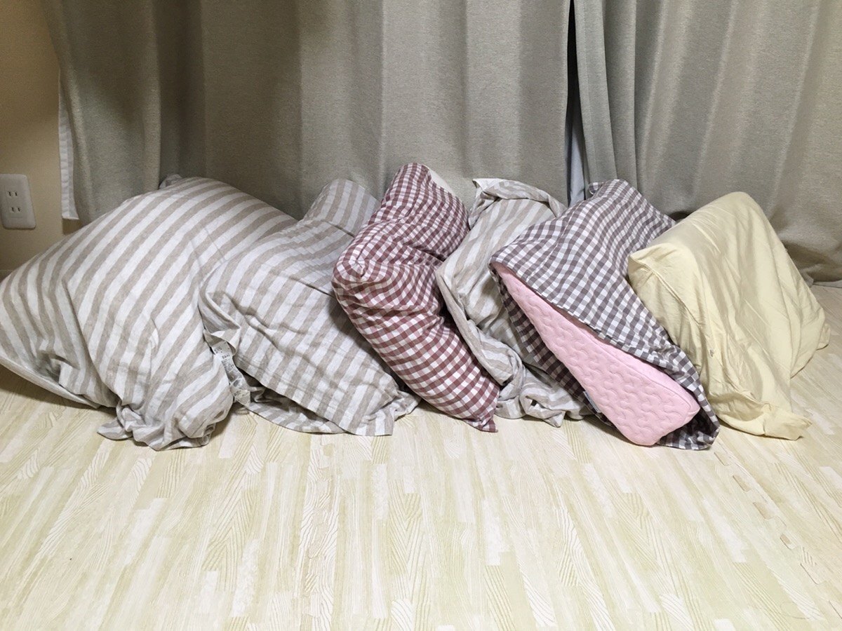 合わなくて買い替えてきた枕が6つ床に並んでいる写真